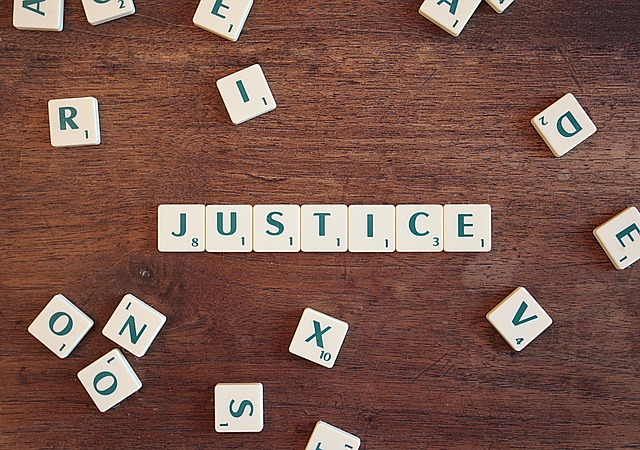 Scrabble letters spelling out the word "Justice"